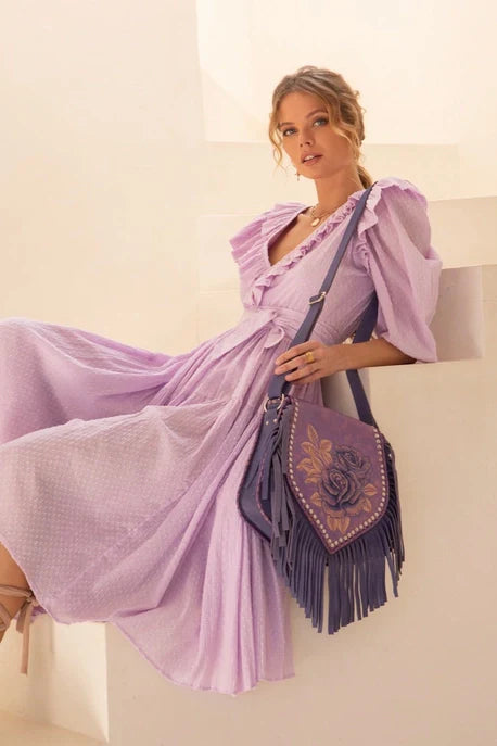 Close-up of the Akaroa Rose Hand Painted Leather Shoulder Bag, Style No. ADBG702A – highlighting artisan floral detailing and fringe on model.