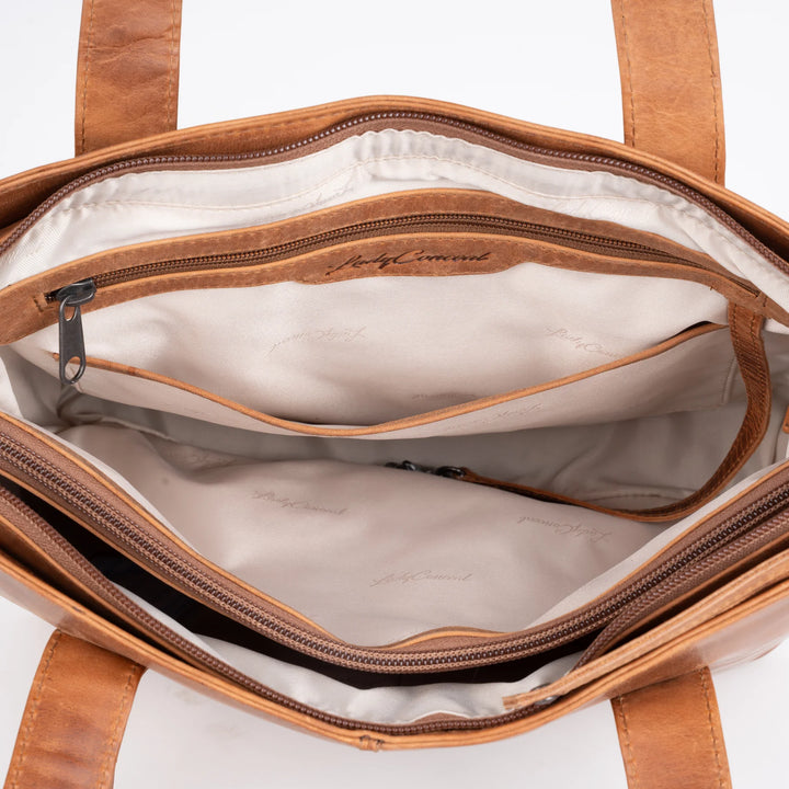 Inside of Reagan tote in Cognac showing lining and storage compartments.