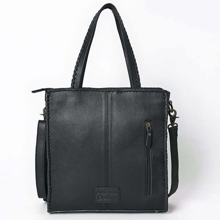 Back of black and white cowhide tote bag showing full-grain leather back panel and Western craftsmanship.
